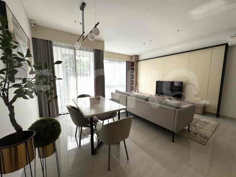 Area ruang tamu dan makan dengan meja makan, kursi abu-abu, sofa, dan pemandangan terbuka.