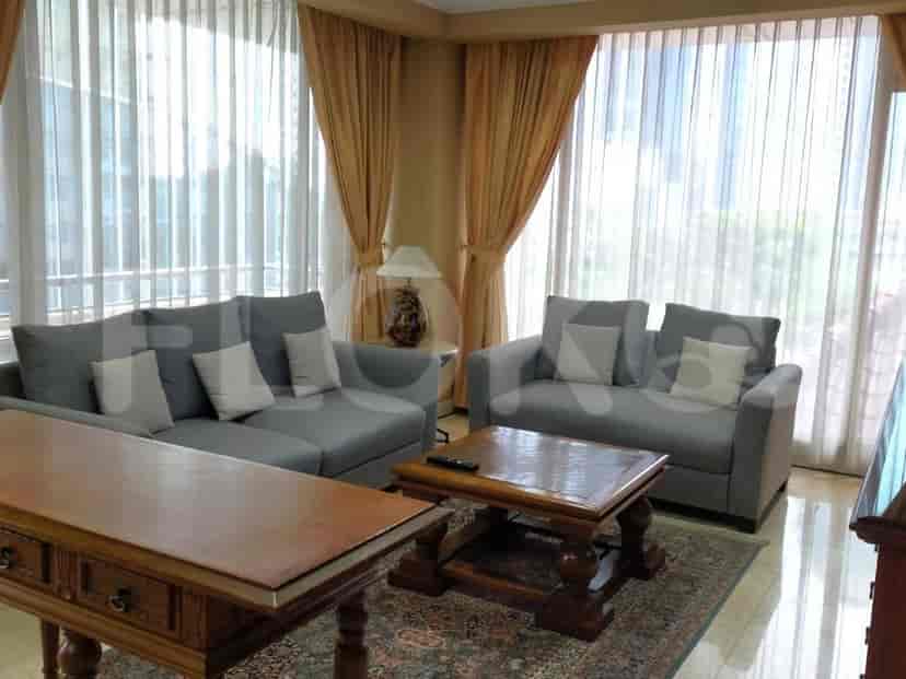 A living room with a grey L-shaped sofa, a small table, and a rug.