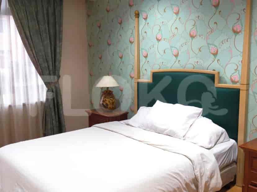 A bedroom with a bed, lamp, and wall design.