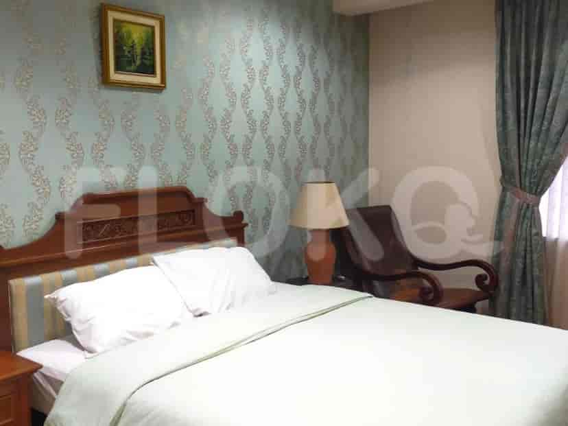 A bedroom with a bed, bedside table, and wall design.