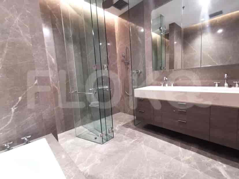 Modern bathroom with marble tiles, glass shower, and a large vanity.