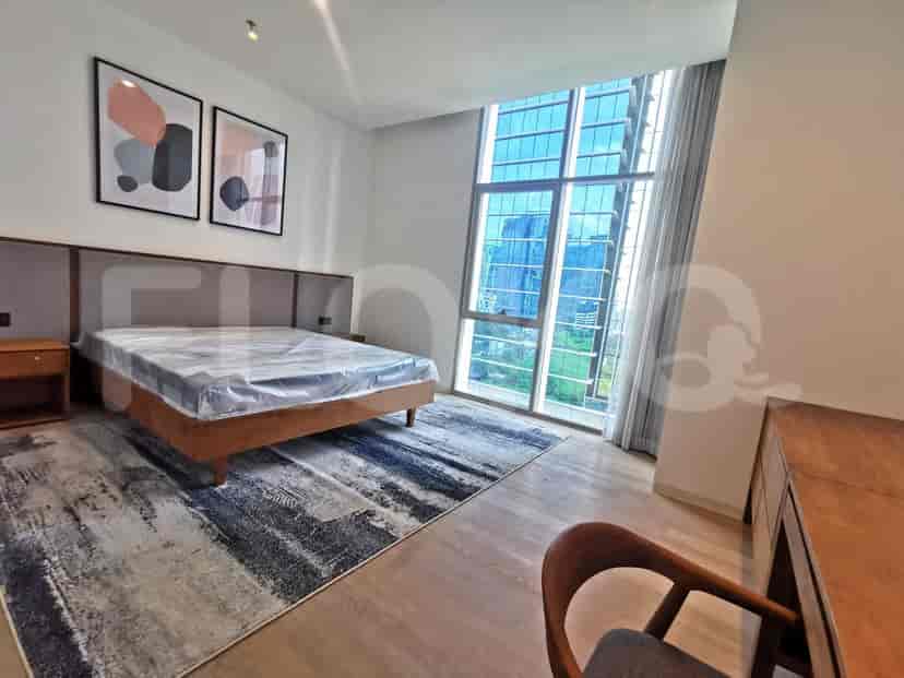 Bedroom with a large bed, artwork, and views of a tall building.