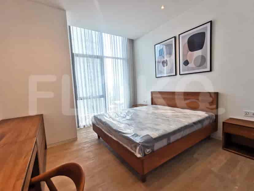 Bedroom featuring a double bed, desk, and sheer curtains.