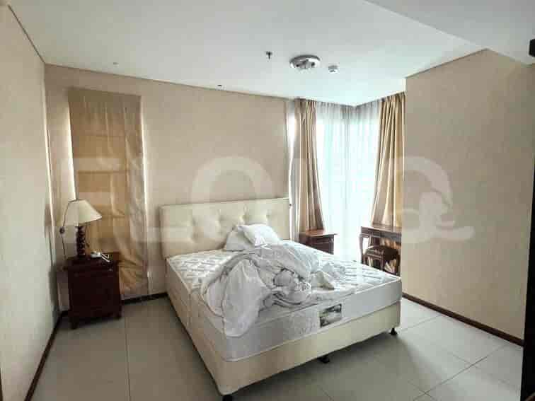 Kamar tidur dengan tempat tidur, meja samping tempat tidur, dan gorden.