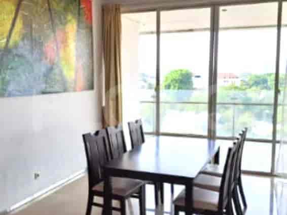 Dining area with a dark wooden dining table and chairs, and a large window with a view.