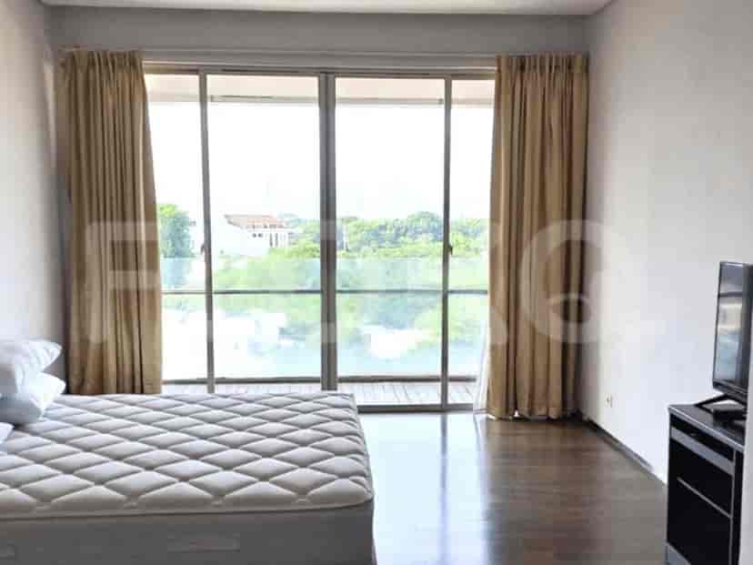 Bedroom with a bed, a TV, and a large window.