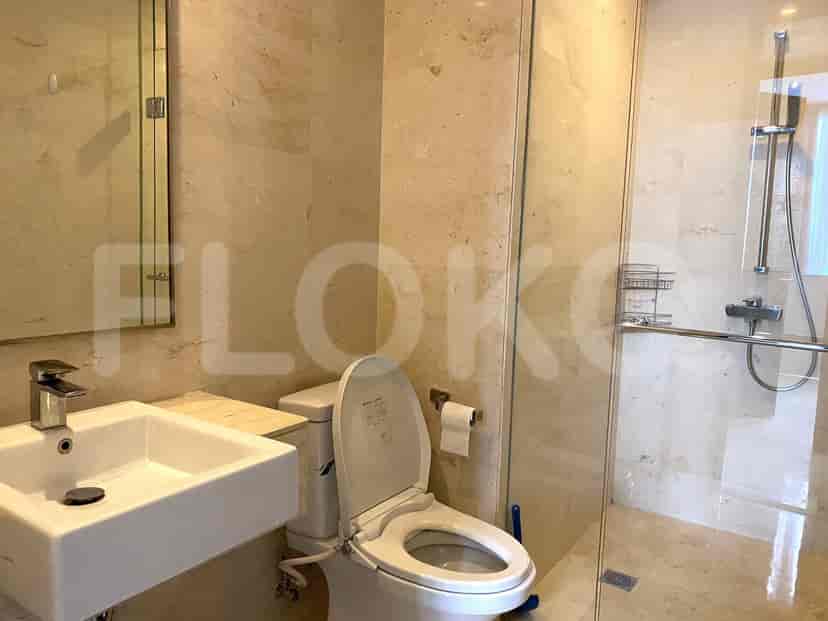 Modern bathroom with a toilet, sink, and a glass shower.