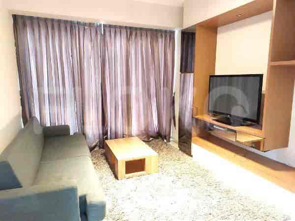 A living room with a grey sofa, TV, and coffee table.