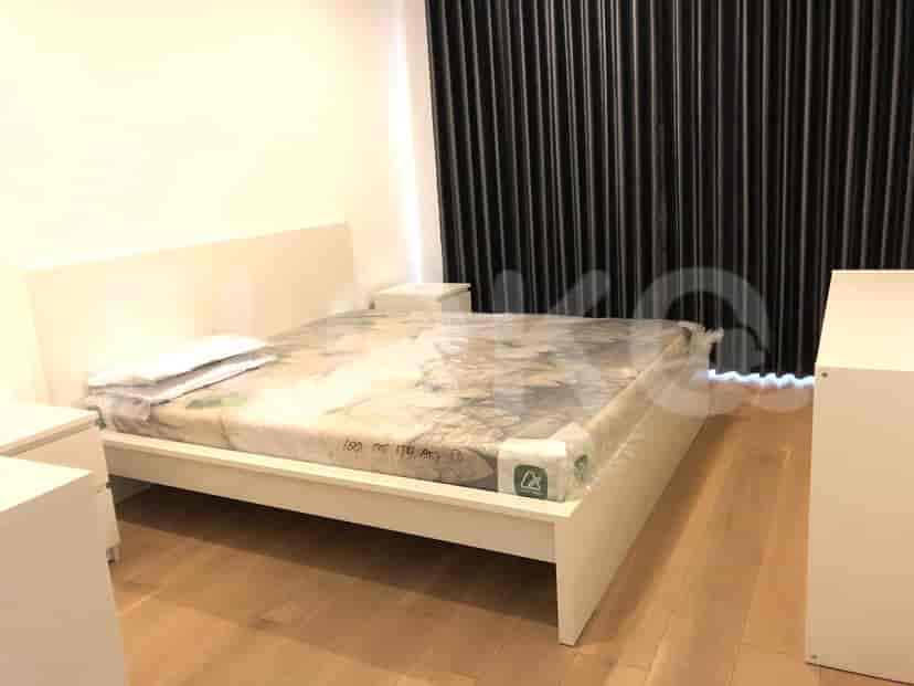 Kamar tidur dengan rangka tempat tidur putih, tempat tidur dengan plastik pelindung, meja samping tempat tidur dan gorden.