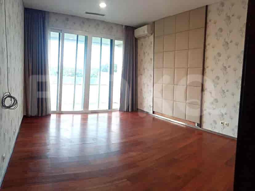 Bedroom with wooden flooring, patterned wallpaper, and large windows.