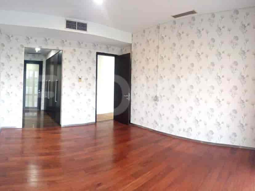 Bedroom with wooden flooring, patterned wallpaper, and a closet.