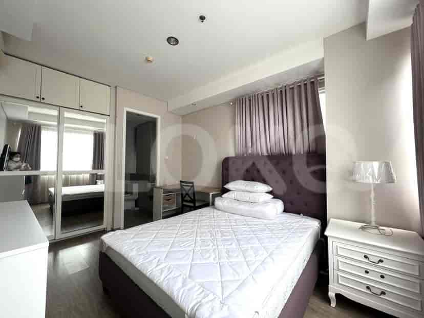 Kamar tidur dengan tempat tidur besar, meja samping tempat tidur putih, dan jendela besar