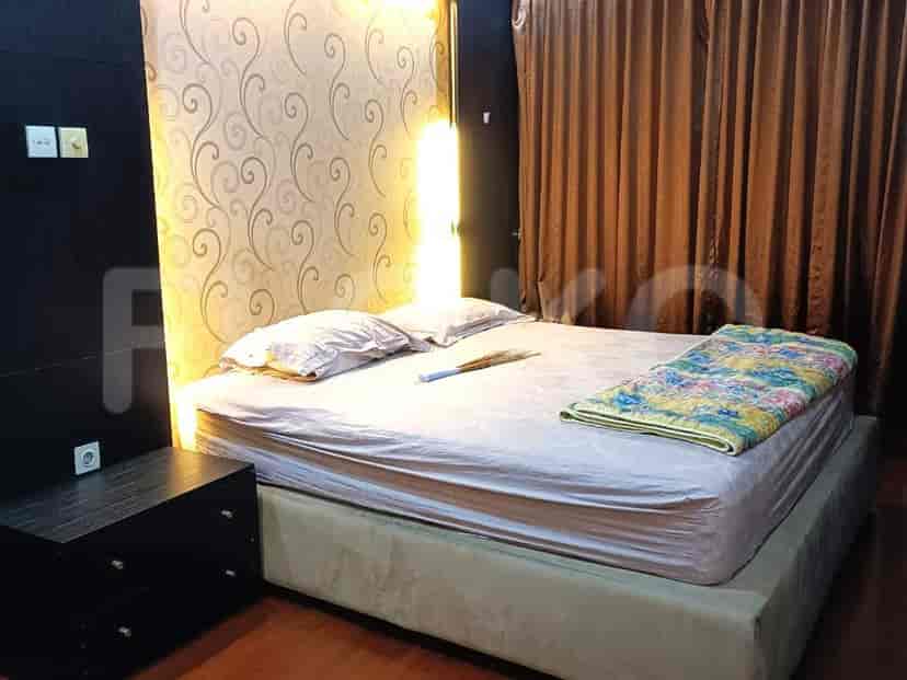 Bedroom with a bed, curtains, and a nightstand.