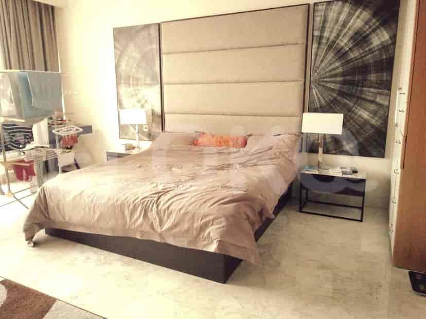 Bedroom with a large bed, side tables and art on the wall.