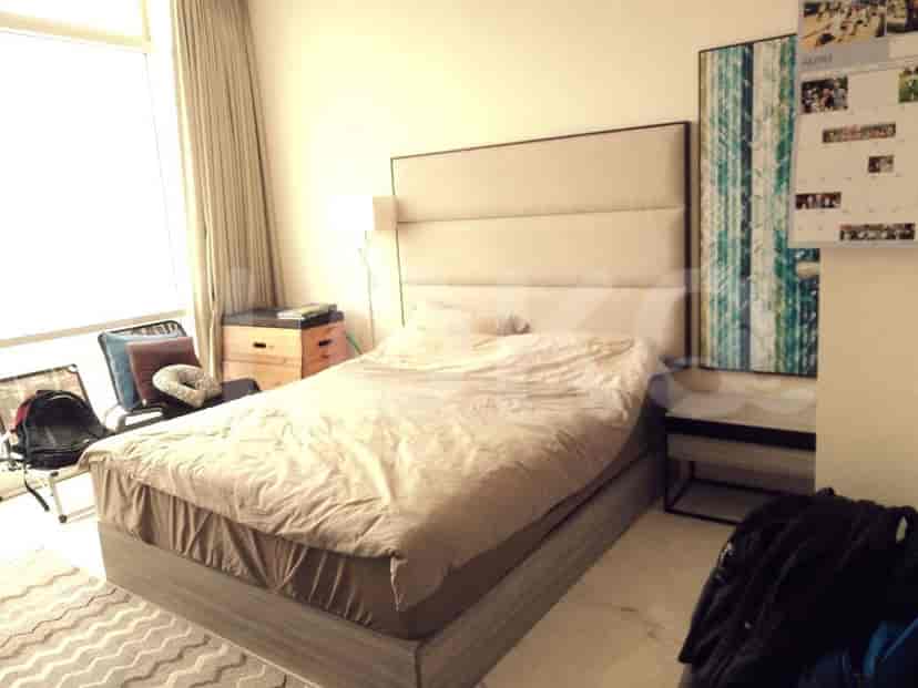 Bedroom with a large bed, side table and decorative pillows.