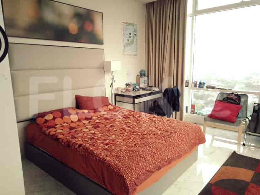 Bedroom with a large bed, side table and desk with a city view.