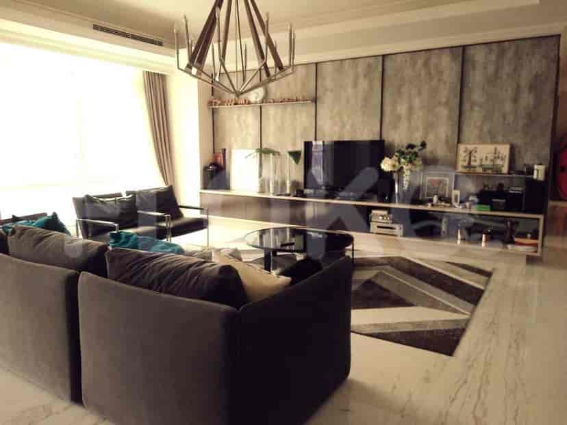 A modern living room with grey sofas, a TV, and large windows.