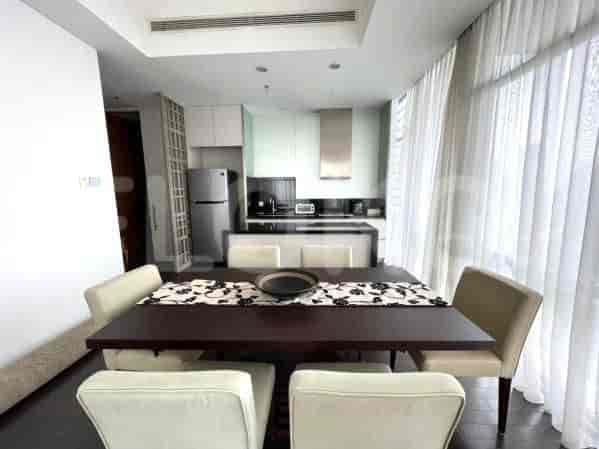 A well-lit dining area connected to a modern kitchen. Features a wooden dining table, chairs, and stainless steel appliances.