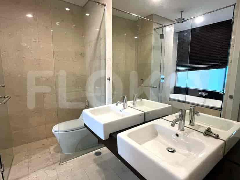 Modern bathroom with glass-enclosed shower, double vanity, and bathtub.