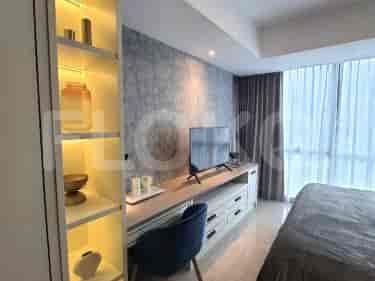 Kamar tidur dengan tempat tidur, lemari pakaian dengan etalase, dan meja.