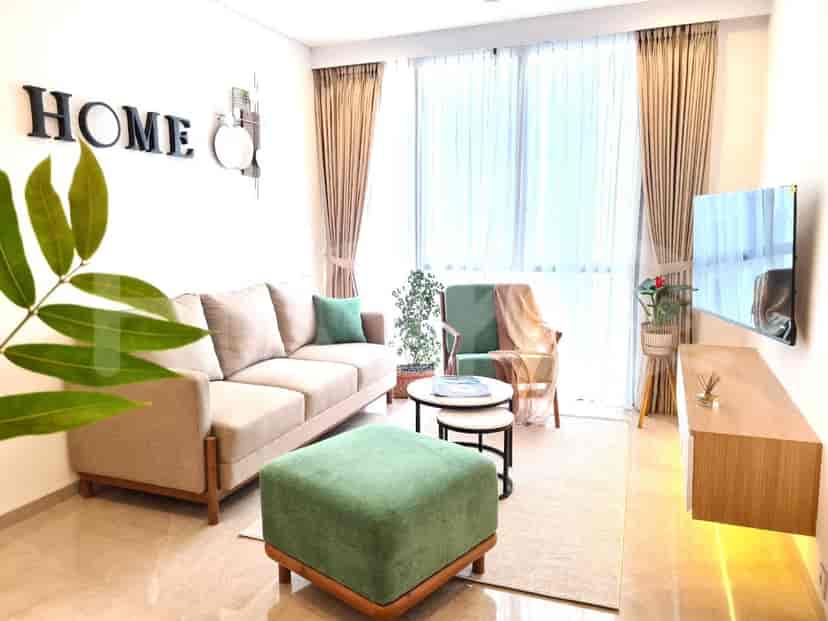 Ruang tamu modern dengan sofa berbentuk L berwarna abu-abu, jendela besar, dan TV.