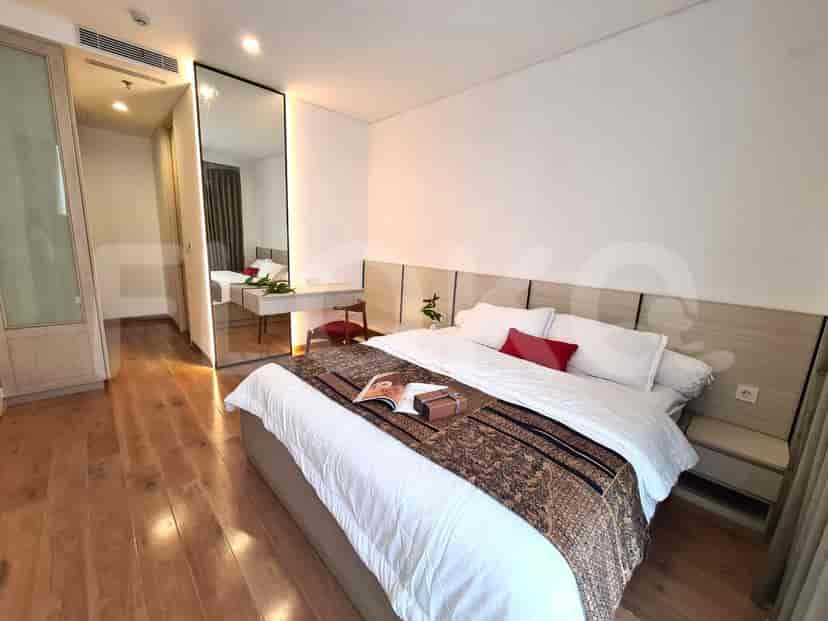 Kamar tidur elegan dengan tempat tidur besar, cermin full-length, dan lantai kayu.