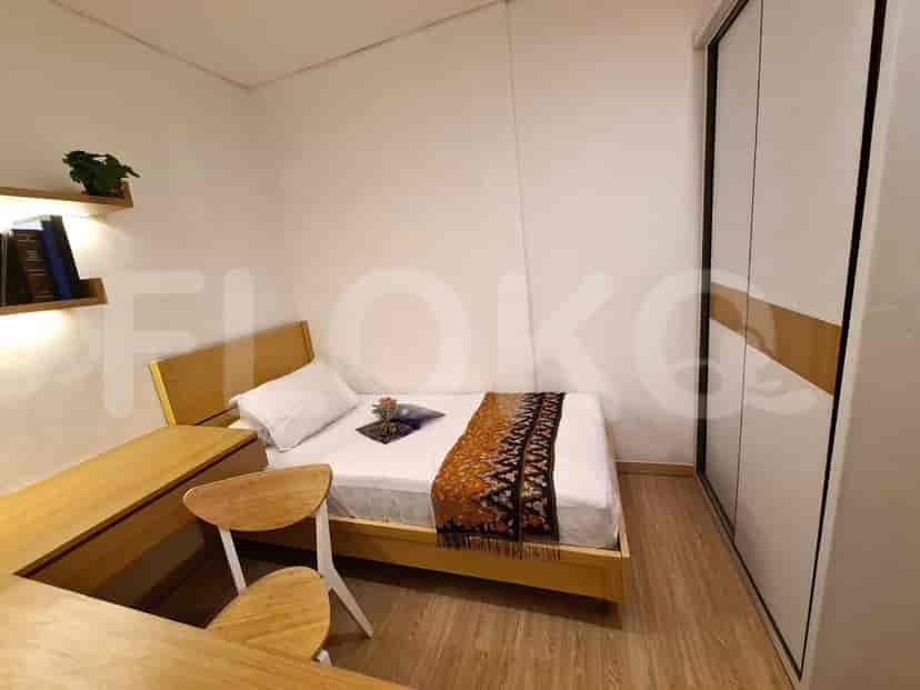 Kamar tidur yang nyaman dengan tempat tidur, meja samping tempat tidur, dan lantai kayu.