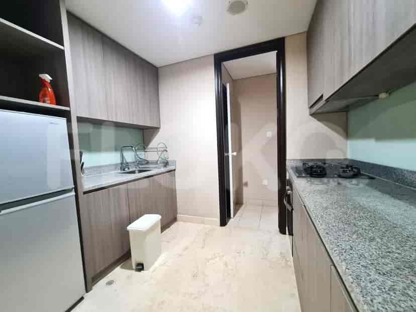 A modern kitchen with wooden cabinets, a stainless steel refrigerator, and a gas stove.