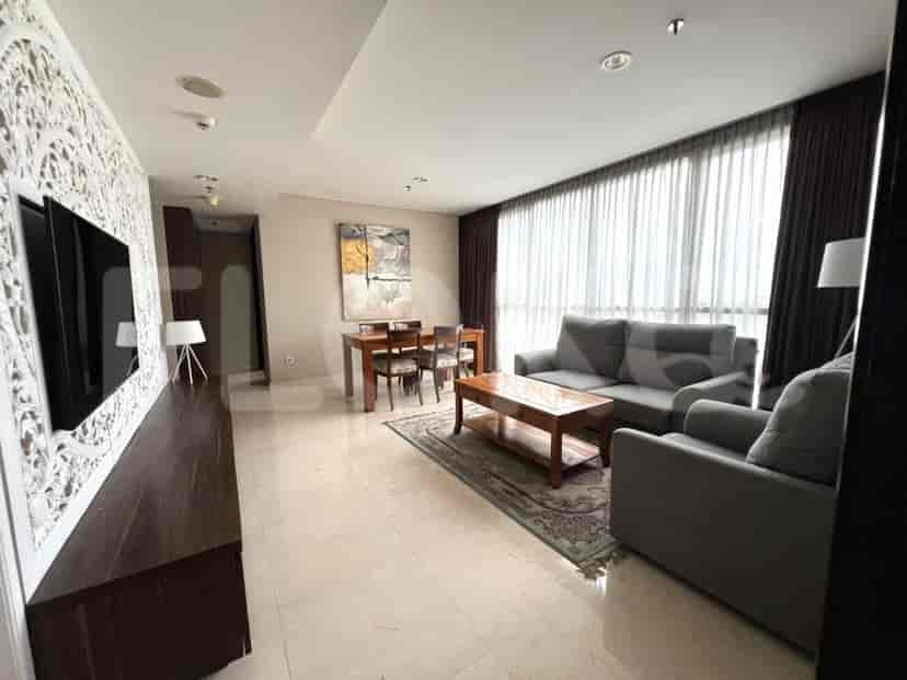 Spacious living room with dining area, sofa, and large windows.