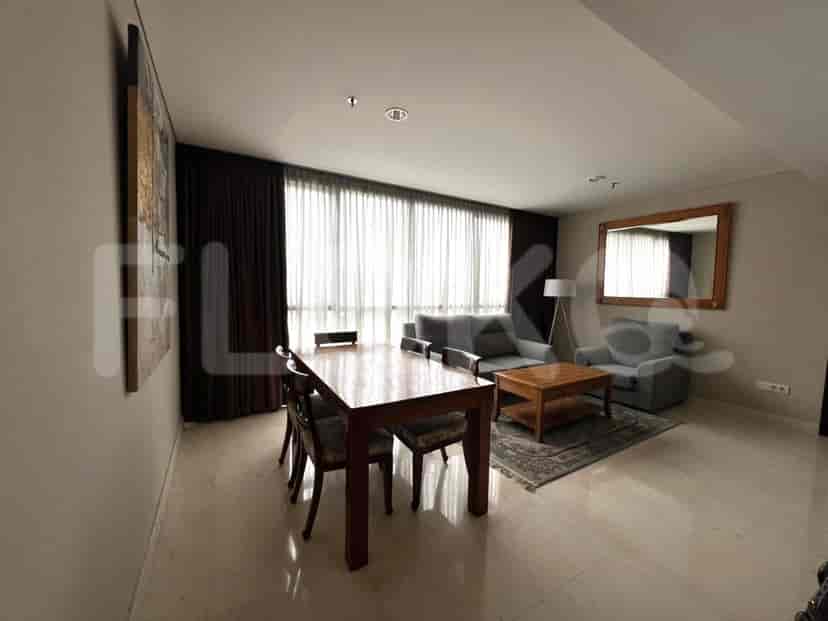 Living room with dining table and mirror, natural light.