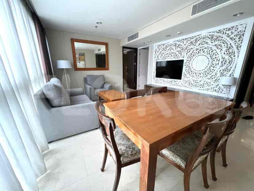 Living room with dining table and decorative wall panel.