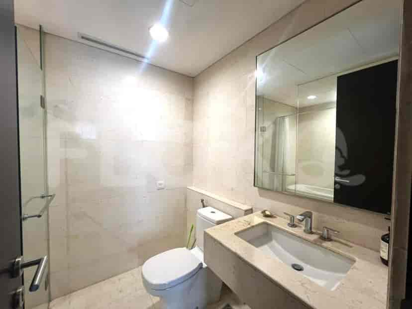 Bathroom with a toilet, sink, and glass shower.