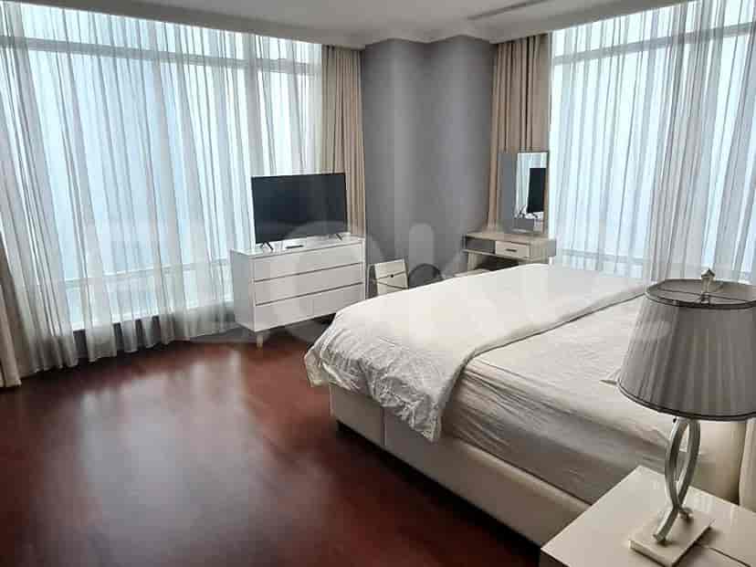 Bedroom featuring a bed, chest of drawers, and large windows.