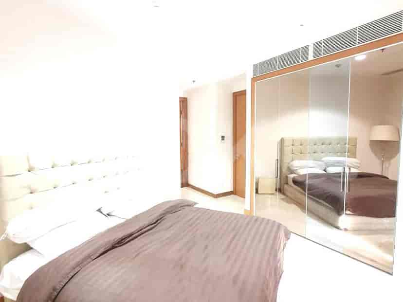 Kamar tidur dengan tempat tidur, lemari bercermin, dan desain kontemporer.