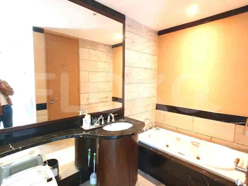 Kamar mandi bergaya dengan bak mandi, cermin, dan wastafel.
