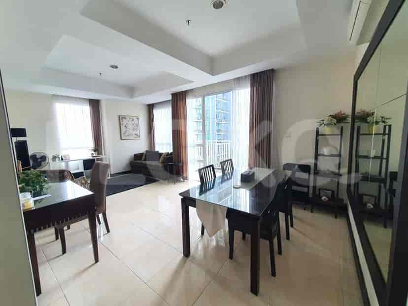 Open-plan living and dining area with a dining table, sofa, and large windows.