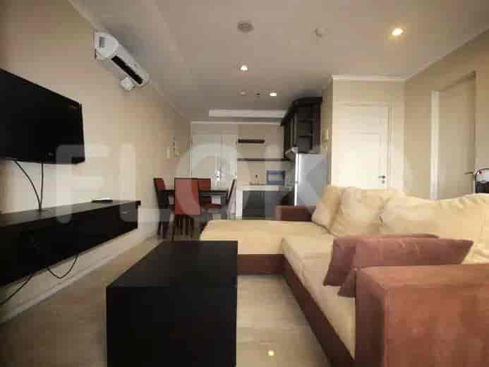 Kombinasi ruang tamu dan dapur yang menampilkan sofa, meja makan, dan dapur terbuka.