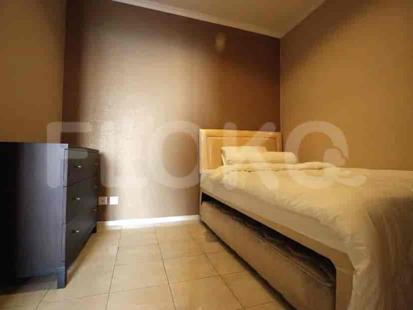 Kamar tidur yang menampilkan tempat tidur, lemari, dan skema warna netral.