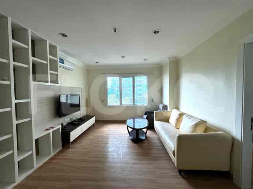 Ruang tamu dengan sofa, TV, dan rak built-in.