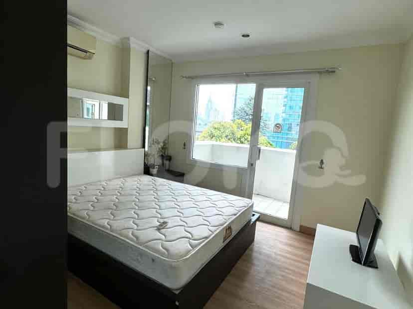 Kamar tidur dengan tempat tidur, akses balkon, dan TV.