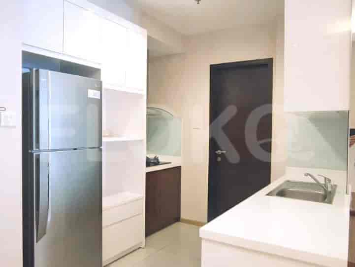 Modern kitchen with white cabinetry, stainless steel appliances, and dark wooden door.