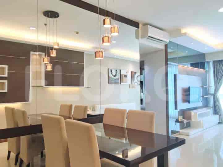 Dining area with a glass table, chairs, and pendant lighting.
