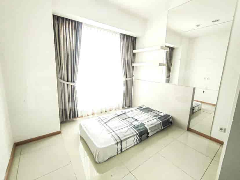 A bedroom with a bed, a window with curtains and shelves, and a mirror.