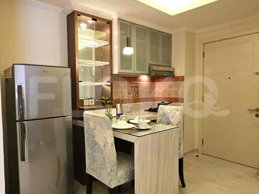 Dapur dengan meja makan, lemari es, dan lemari.