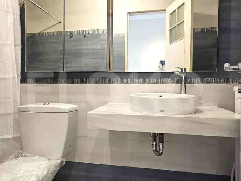 Kamar mandi dengan toilet, wastafel, dan cermin.