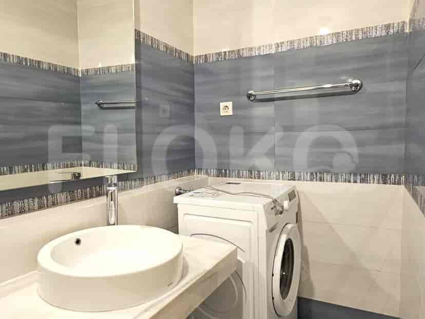 Kamar mandi yang menampilkan mesin cuci, wastafel, dan area pancuran.