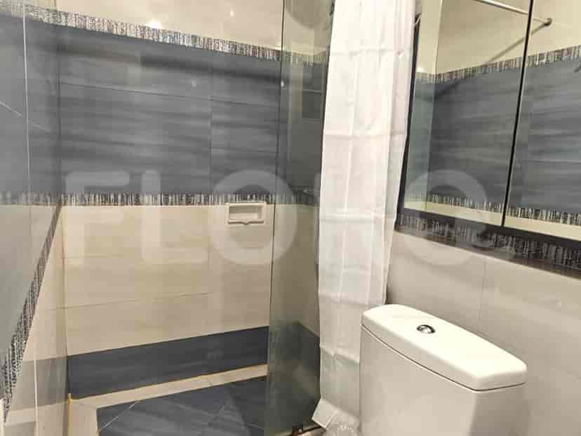 Kamar mandi yang menampilkan toilet, wastafel, dan area pancuran.