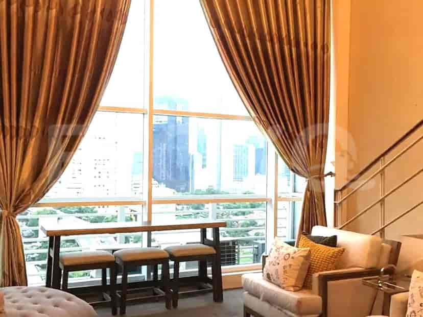 Area tempat tinggal dengan jendela besar, meja bar, dan pengaturan tempat duduk.