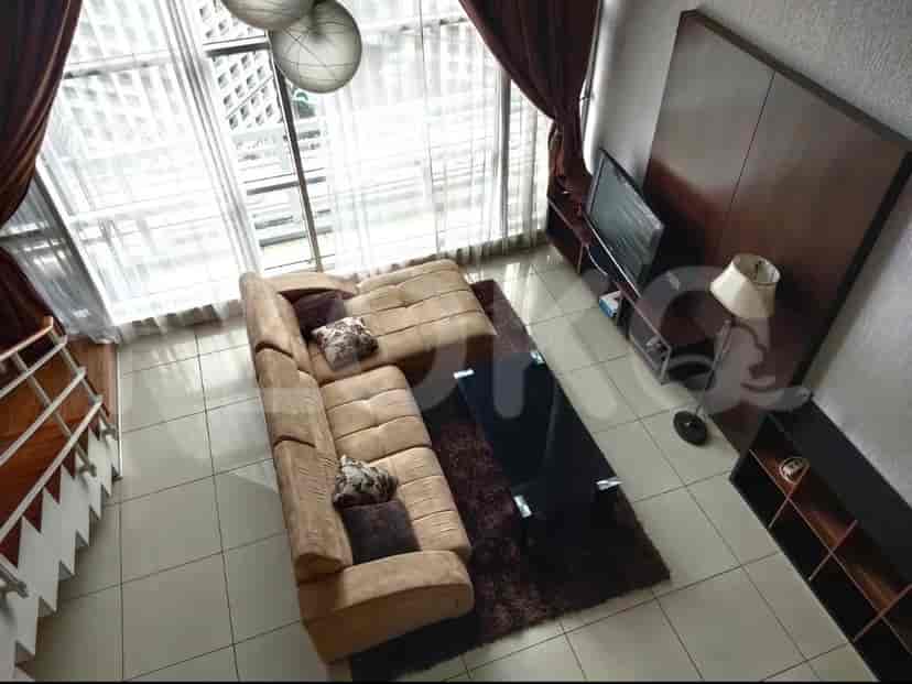 Tampilan dari atas ruang tamu modern dengan sofa berbentuk L dan jendela besar.