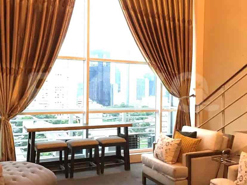 Ruang tamu dengan sofa, meja kopi, dan seni.